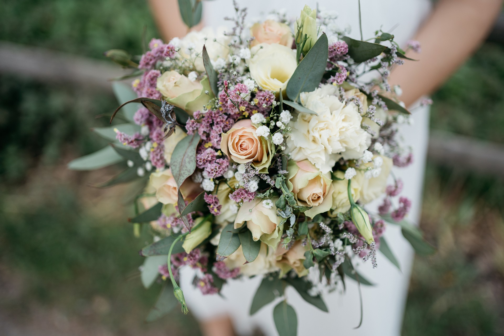 the bride holds a colorful wedding bouquet in her hands